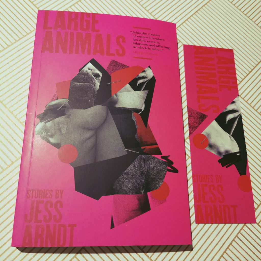 Photograph of a paperback copy of Large Animals with a themed bookmark.
